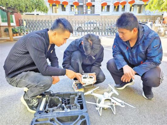 10月22日，在陜西工程科技高級技工學校，楊帆（左）指導學生操控無人機。