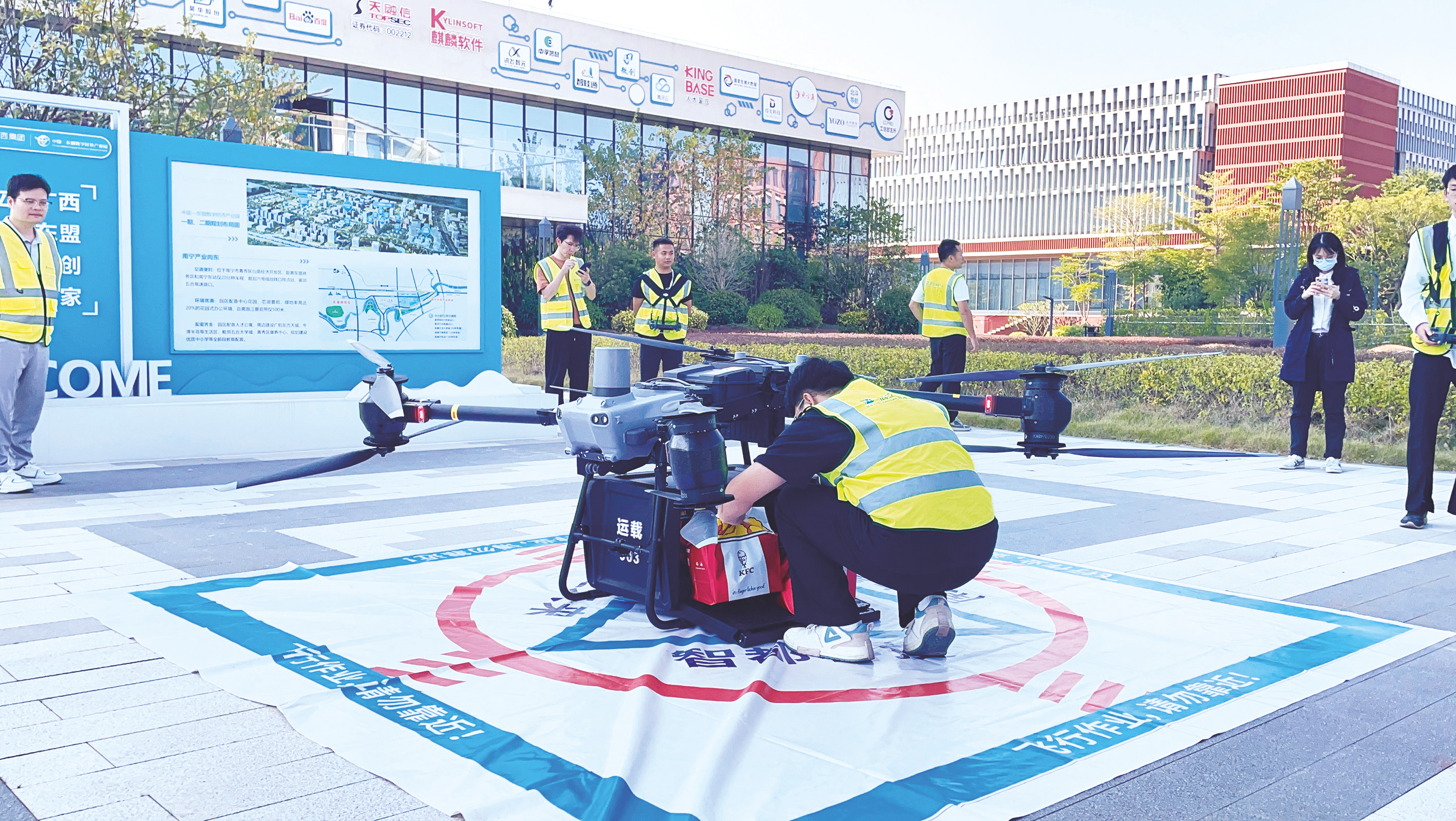 ????②南寧首單“低空外賣”成功送達配送點后，工作人員取貨。（韓樂聞 攝）